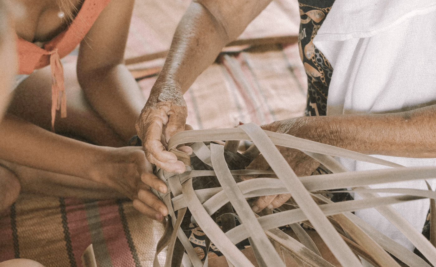 Hands weaving palm leaves